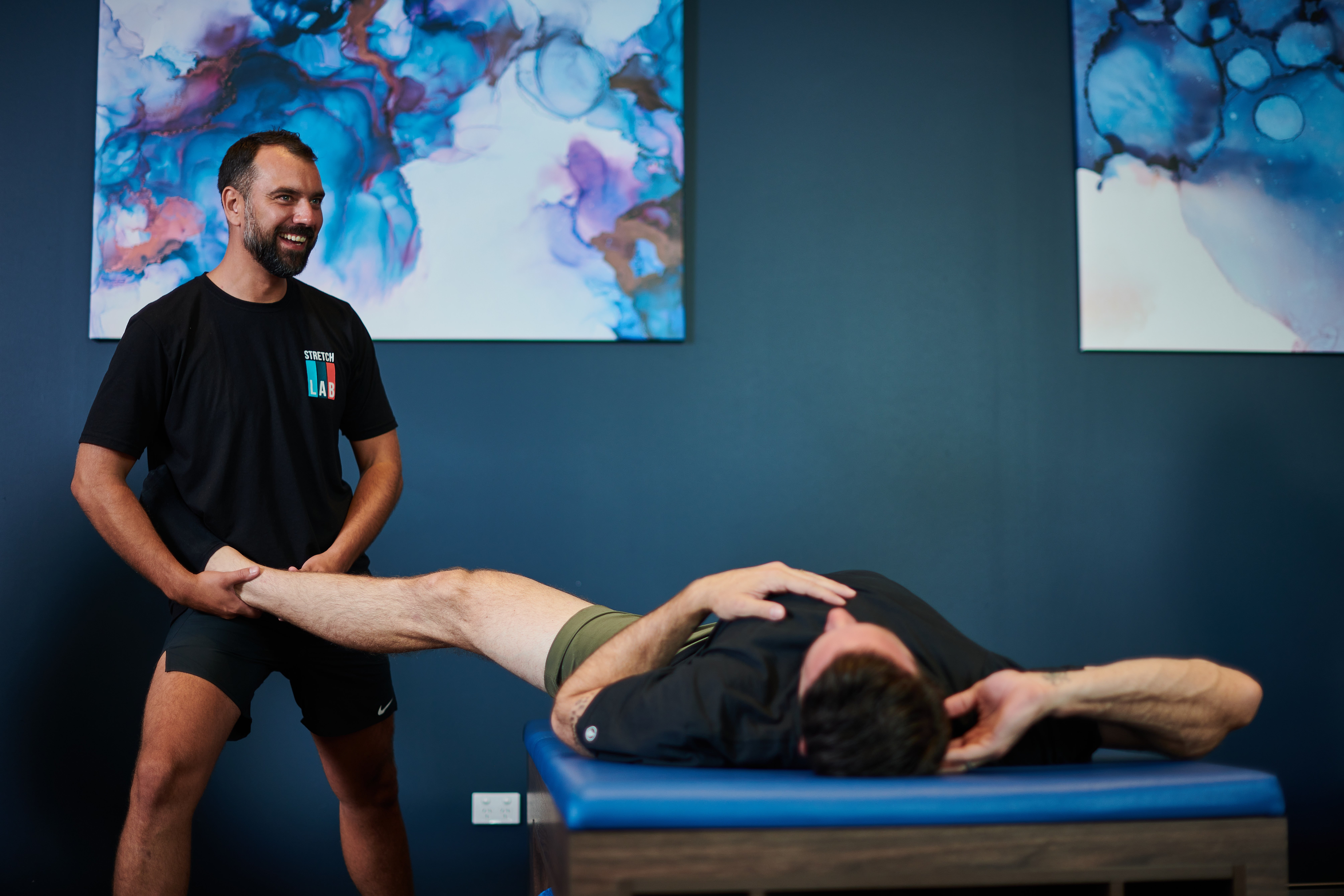 Stretch lab instructor stretching a man's leg muscles
